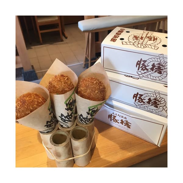 片手にコロッケ食べながら